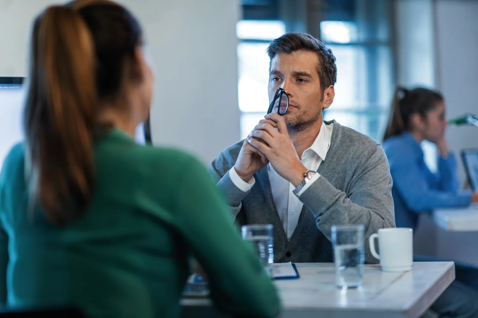 Two people in a meeting, paying attention to the person speaking.